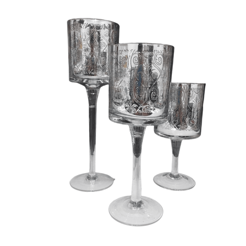 Trio de castiçais com velas criando iluminação acolhedora e efeitos de luz com arabescos.
