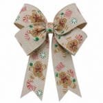 Fita decorativa natalina aramada com estampas gingerbread utilizada na criação de laços volumosos para decoração de Natal.