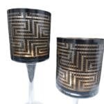 Castiçais com velas criando iluminação aconchegante e destacando o padrão geométrico elegante.