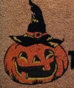 Capacho de Halloween em fibra de coco, medindo aproximadamente 33x60cm, com estampa de abóbora e frase Doces ou Travessuras.