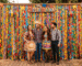 Painel formado por tiras de tecido chita colorido criando um fundo perfeito para fotos em uma festa junina.