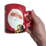 Caneca temática da Coleção Natal 2026, produzida em cerâmica com acabamento em relevo e excelente riqueza de detalhes para decoração natalina.