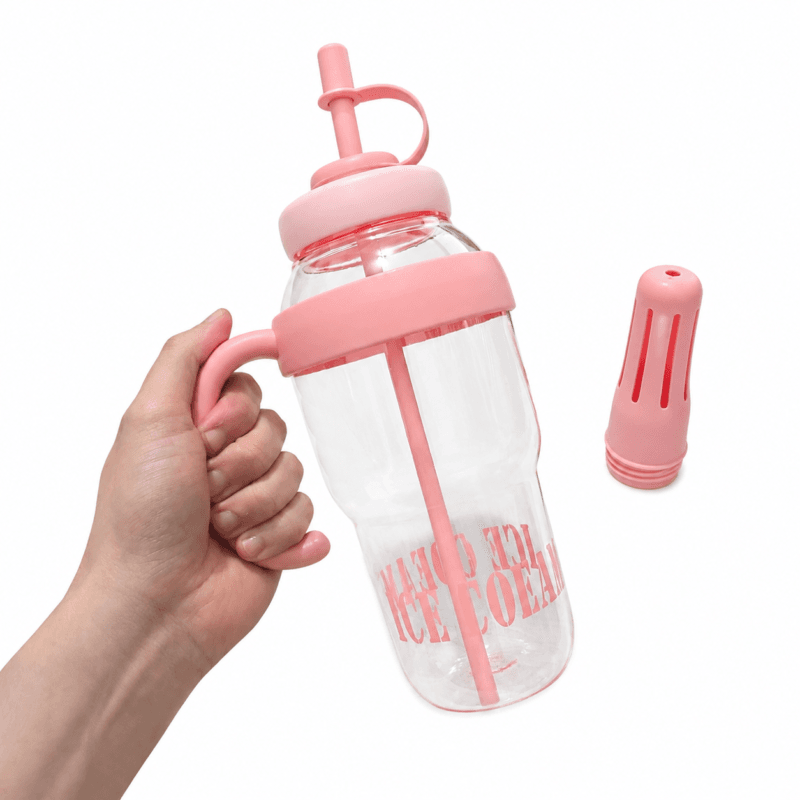 Garrafa plástica na cor rosa, com tampa, vedação de silicone, ponteira e suporte interno para mexer a bebida.