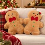 Casal de almofadas Gingerbread decorativas, com um personagem menino e uma personagem menina, acabamento peluciado, laços vermelhos e detalhes natalinos.