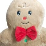 Almofadas Gingerbread menino e menina compondo uma decoração natalina aconchegante sobre um sofá, acompanhadas por elementos decorativos em vermelho e verde.